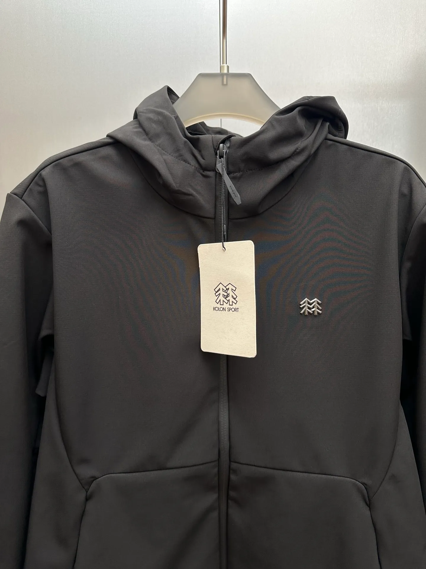 KOLON SPORT/Kolon Outdoor Hooded Brushed Soft Shell Jacket, Windproof, Water-Repellent and Warm Jacket. It is a magical jacket that combines urban commuting with light outdoor use. The composite hooded soft-shell jacket with brushed base is windproof and water-repellent, with a horseshoe sleeve design that is insulating and comfortable to wear. The inner side uses an elastic band, which has a simple appearance and a good fit. The inner mesh fleece is Breathable and prevents sweating. It has a hooded design and a built-in drawstring at the hem to lock in wind and keep warm. The metal logo on the chest is painted with piano paint, the color is uniform, and it is durable for washing and bed wear without fading. The zipper is original and customized with rich details. Three-dimensional tailoring, not tight, easy to control various body shapes, whether it is daily work, hiking or walking on weekends, it is practical and comfortable to wear. Color: Black, Dark Beige Sizes: M-2x L